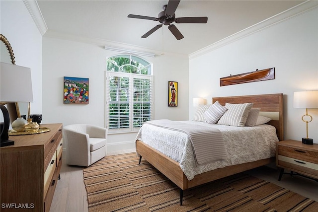 bedroom with crown molding, light hardwood / wood-style flooring, and ceiling fan