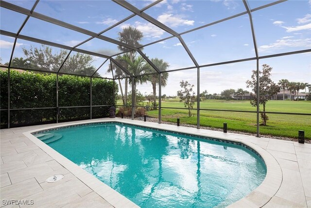 view of swimming pool with a lanai, a patio, and a lawn