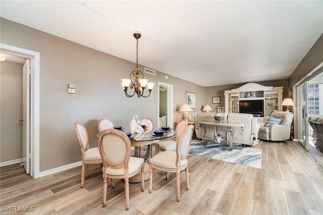 dining space with an inviting chandelier and light hardwood / wood-style flooring