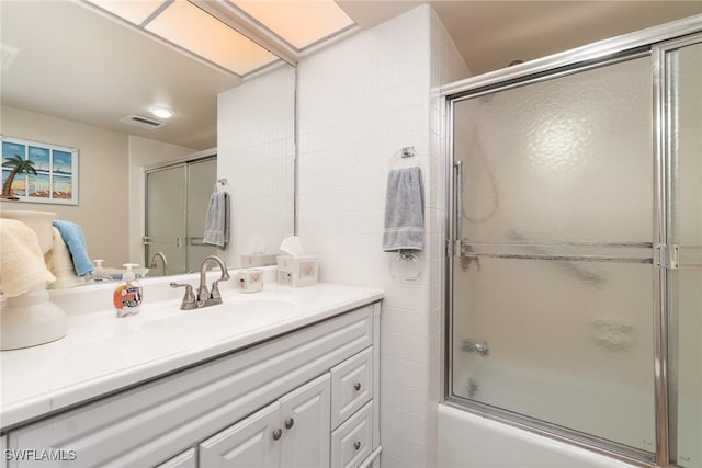 bathroom with vanity and shower / bath combination with glass door