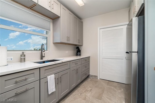 kitchen featuring sink, gray cabinetry, and stainless steel fridge