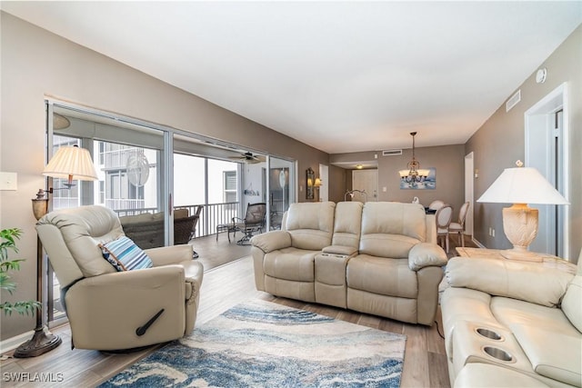 living room featuring an inviting chandelier and light hardwood / wood-style floors