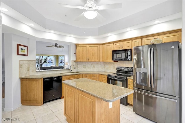 kitchen featuring sink, a center island, light stone counters, decorative backsplash, and black appliances