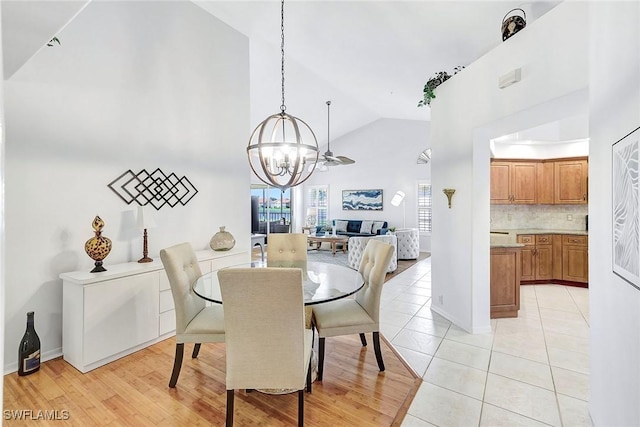 tiled dining area with high vaulted ceiling and a notable chandelier