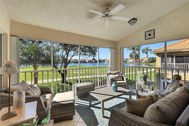 sunroom featuring ceiling fan, a water view, and vaulted ceiling