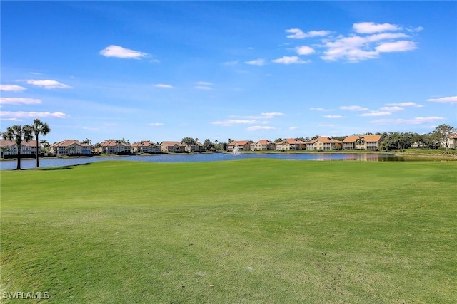 view of property's community with a lawn and a water view