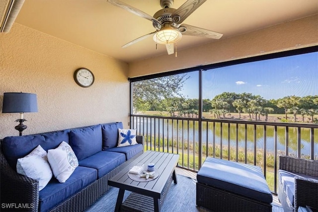 sunroom with a water view and ceiling fan