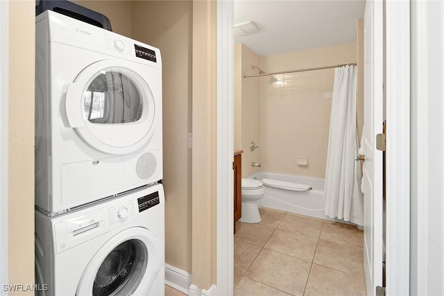 washroom with light tile patterned floors and stacked washer and dryer