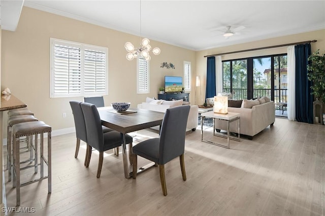 dining room with a wealth of natural light, crown molding, ceiling fan with notable chandelier, and light wood-type flooring