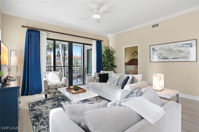 living room featuring ceiling fan, light hardwood / wood-style floors, and crown molding