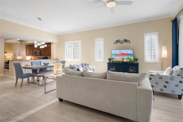 living room with light hardwood / wood-style flooring, ceiling fan with notable chandelier, and ornamental molding