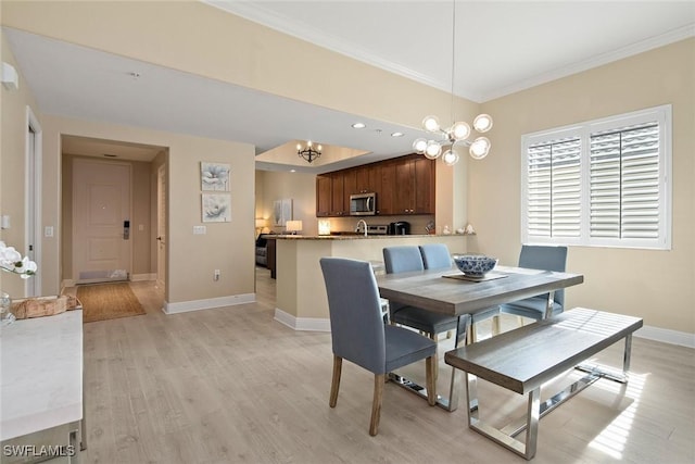 dining area with crown molding, light hardwood / wood-style flooring, and an inviting chandelier