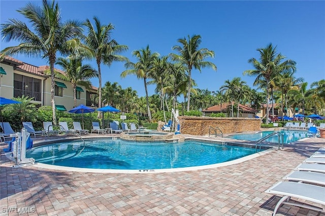 view of swimming pool with a patio area and a community hot tub