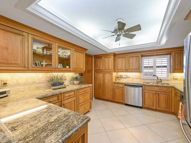 kitchen featuring tasteful backsplash, a raised ceiling, sink, dishwasher, and light tile patterned flooring