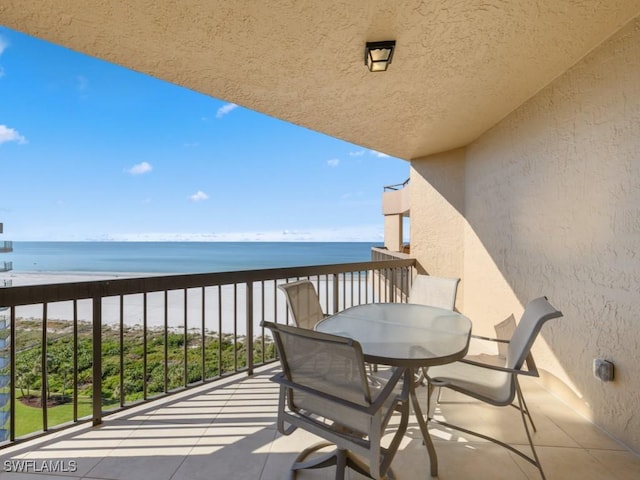 balcony featuring a water view and a view of the beach