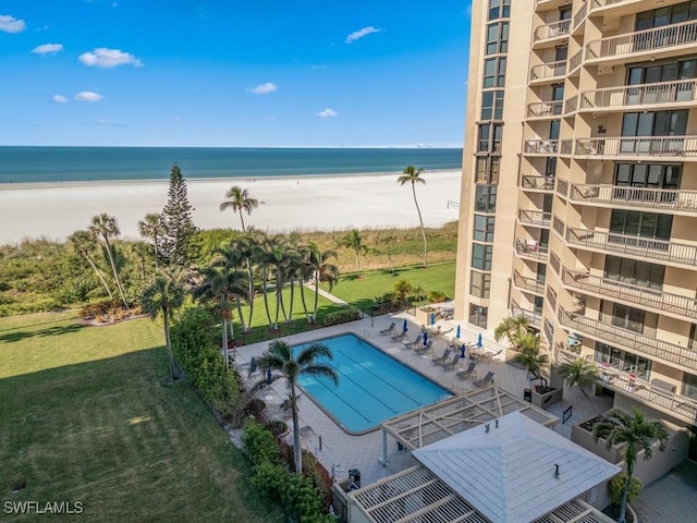 view of swimming pool featuring a view of the beach and a water view