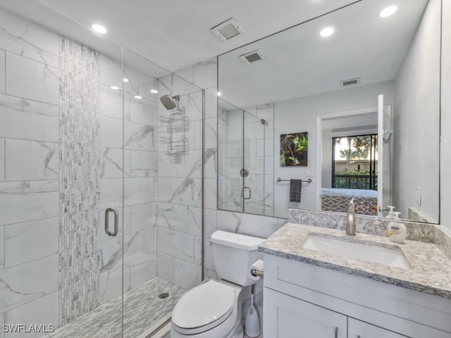 bathroom featuring vanity, toilet, and a shower with door