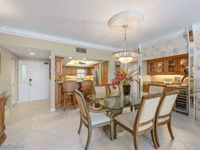 tiled dining space featuring beverage cooler and ornamental molding