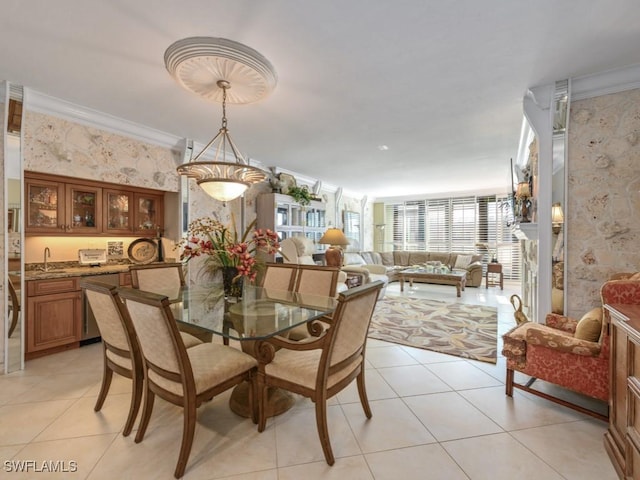 tiled dining room featuring ornamental molding and sink