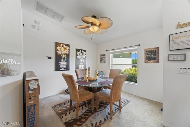 carpeted dining area featuring ceiling fan and vaulted ceiling