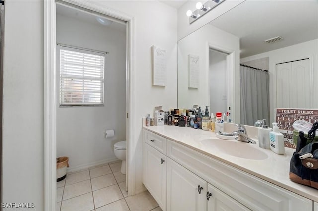 bathroom featuring tile patterned floors, vanity, and toilet