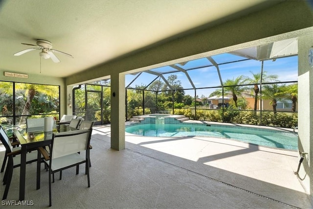 view of pool featuring glass enclosure, an in ground hot tub, ceiling fan, and a patio