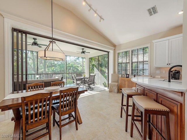 dining area with ceiling fan, light tile patterned floors, and lofted ceiling