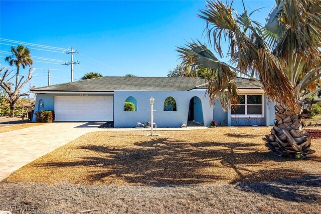 ranch-style house with stucco siding, a garage, and driveway