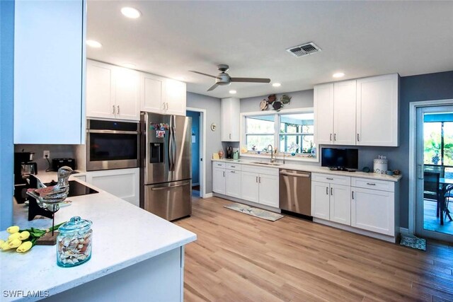 kitchen with white cabinets, stainless steel appliances, a healthy amount of sunlight, and sink