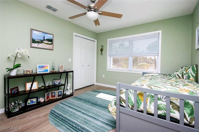 bedroom featuring hardwood / wood-style flooring, ceiling fan, and a closet