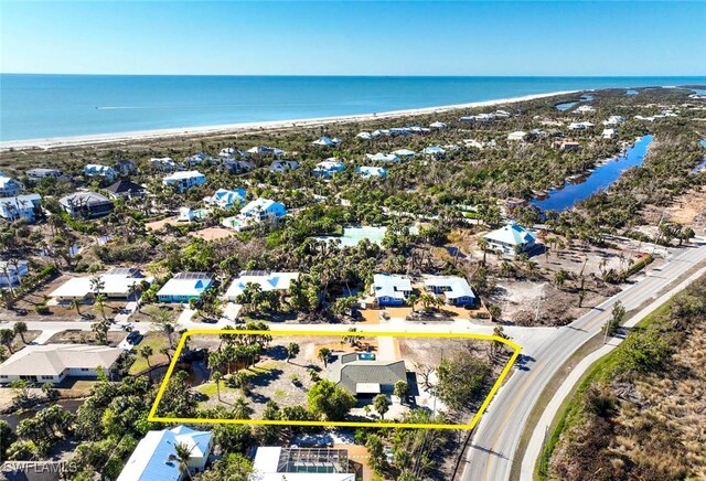 birds eye view of property with a water view and a beach view