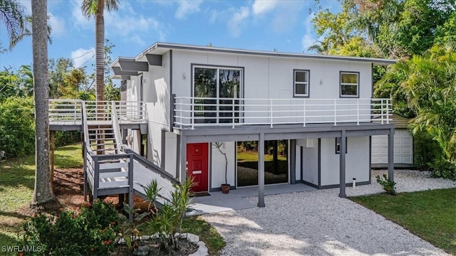 rear view of property featuring a balcony and a deck