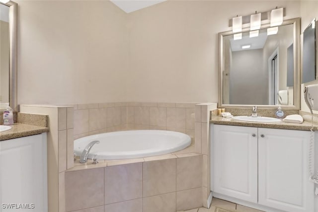 bathroom featuring vanity, tiled bath, and tile patterned floors