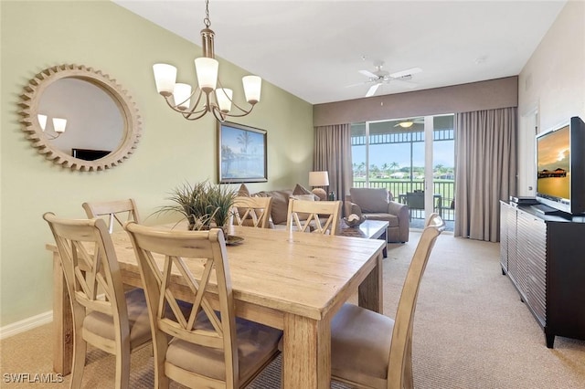 dining room featuring ceiling fan with notable chandelier and light colored carpet