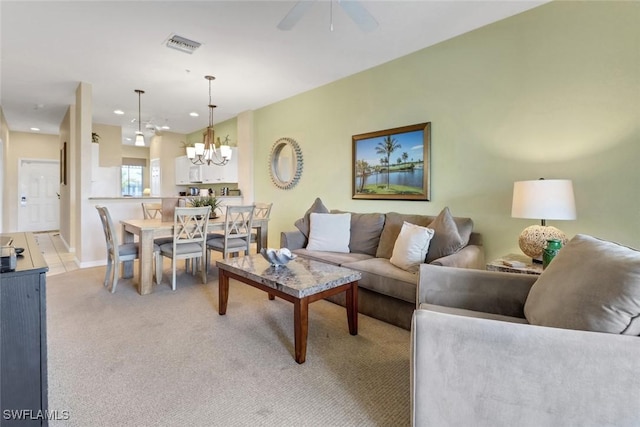 living room with ceiling fan with notable chandelier and light carpet