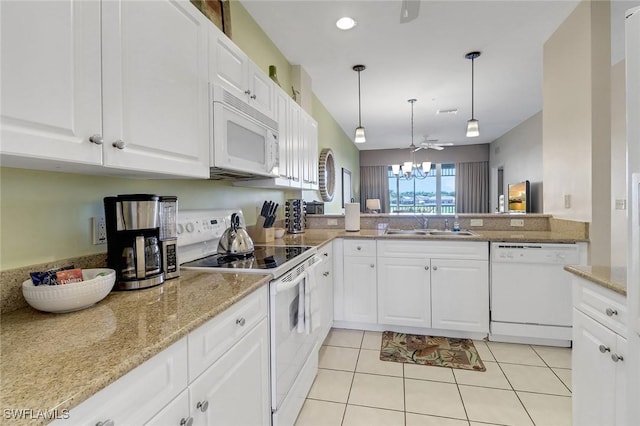 kitchen featuring white appliances, sink, light tile patterned floors, white cabinetry, and hanging light fixtures