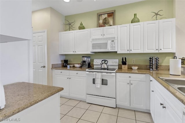 kitchen featuring white cabinetry, sink, light tile patterned floors, and white appliances