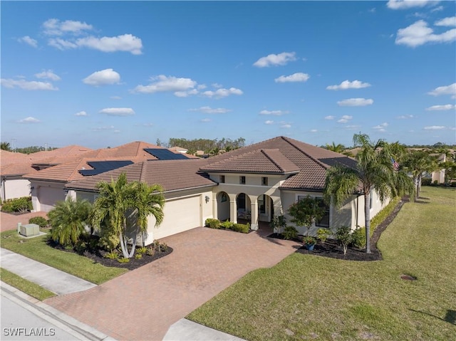 mediterranean / spanish-style home featuring a garage and a front yard