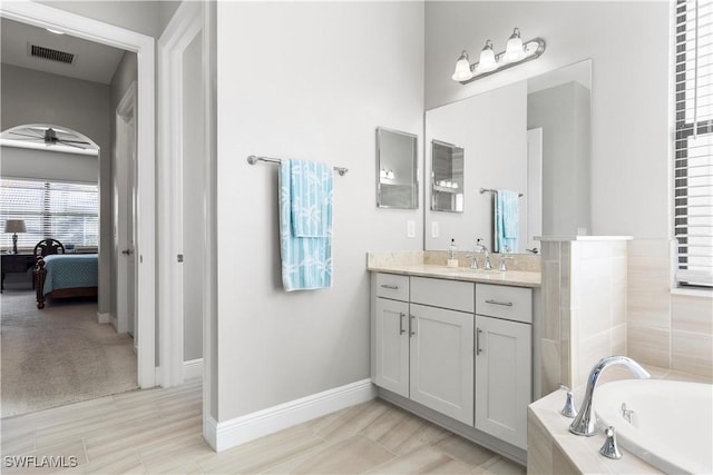 bathroom with a bath, vanity, and ceiling fan