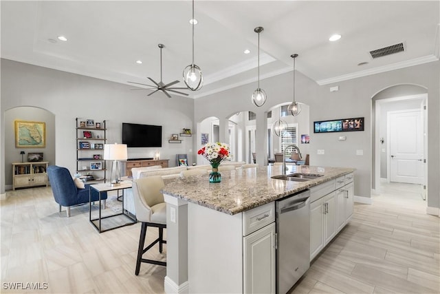 kitchen featuring dishwasher, sink, hanging light fixtures, an island with sink, and white cabinets