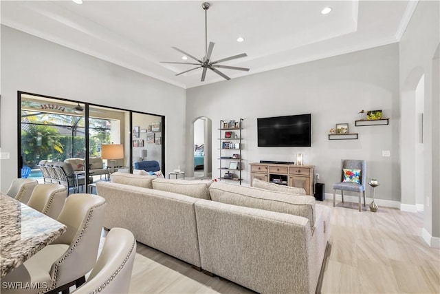 living room with ceiling fan, crown molding, and light hardwood / wood-style flooring