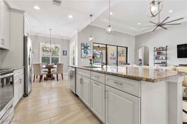 kitchen featuring hanging light fixtures, a center island, white cabinets, and stainless steel appliances