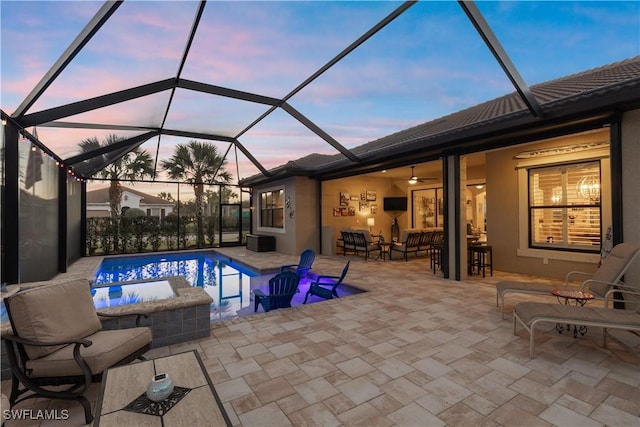 exterior space with glass enclosure, a swimming pool with hot tub, and ceiling fan