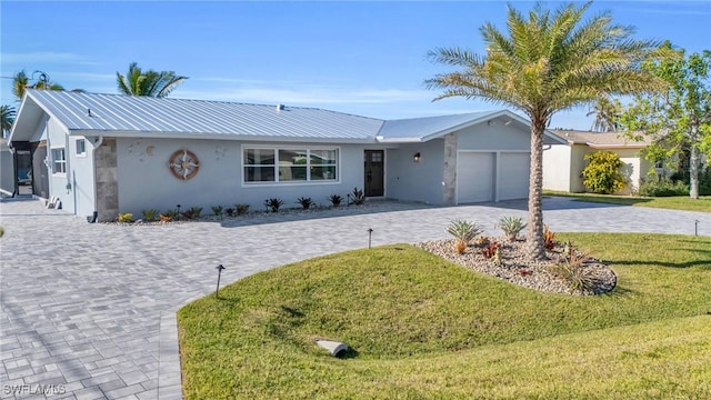 single story home featuring a front lawn and a garage