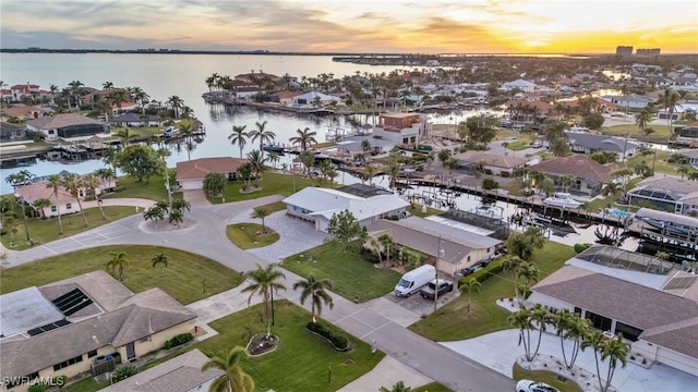 aerial view at dusk featuring a water view