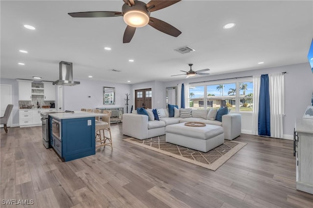 living room featuring light wood-type flooring and ceiling fan