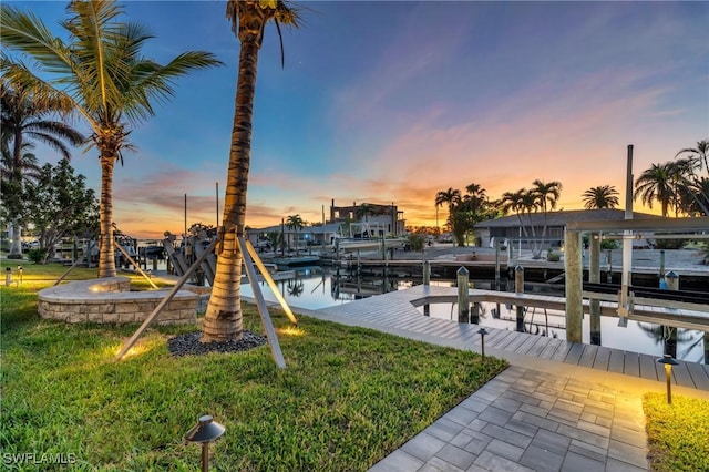 view of dock featuring a water view and a yard