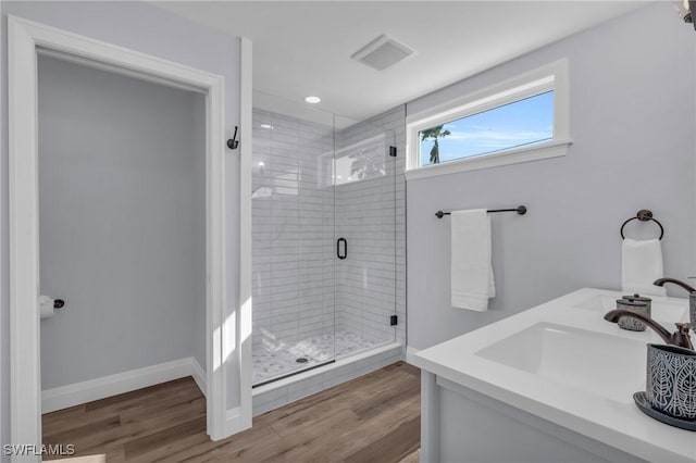 bathroom featuring hardwood / wood-style floors, walk in shower, and sink