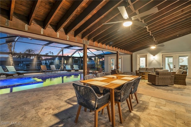 patio terrace at dusk with an outdoor hangout area, glass enclosure, and ceiling fan