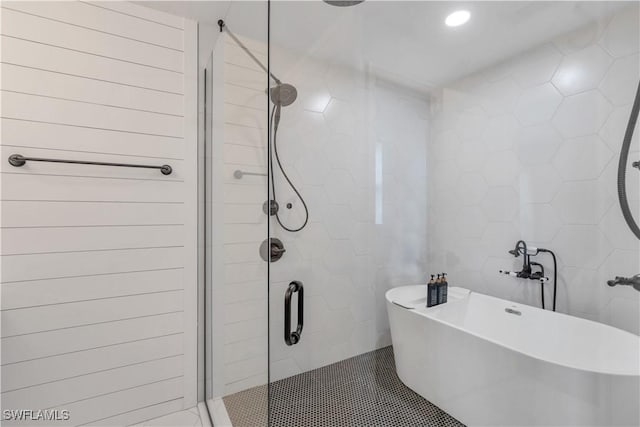 bathroom featuring tile walls and independent shower and bath